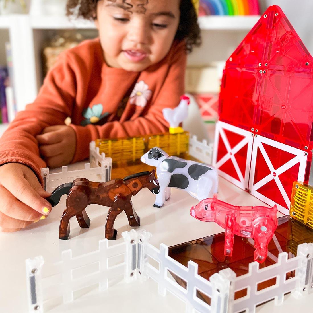 child playing with pieces from the Magna-Tiles Farm Animals 25-Piece Set