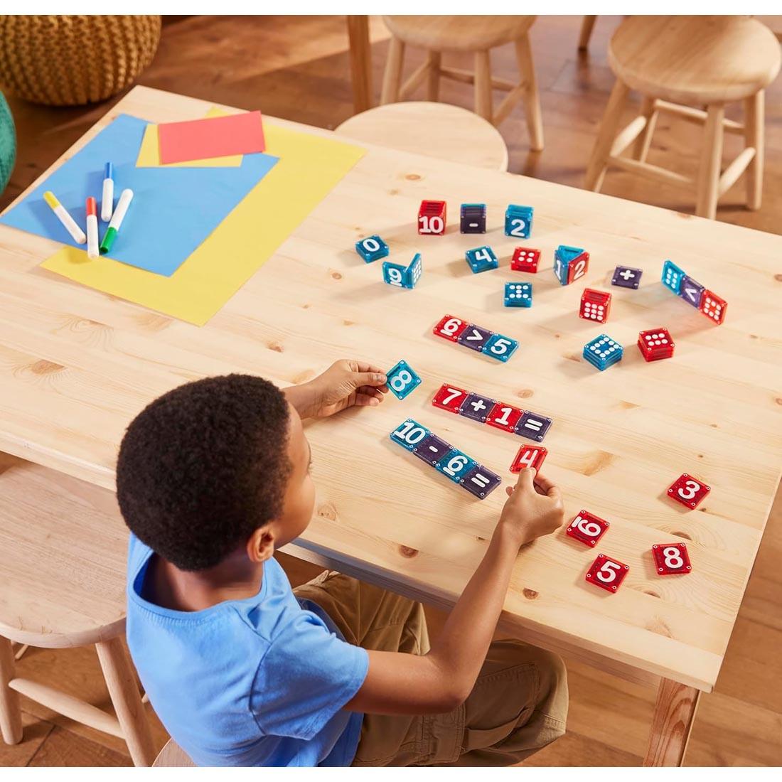 child using the Magna-Tiles microMAGS Learn Numbers 56-Piece Set