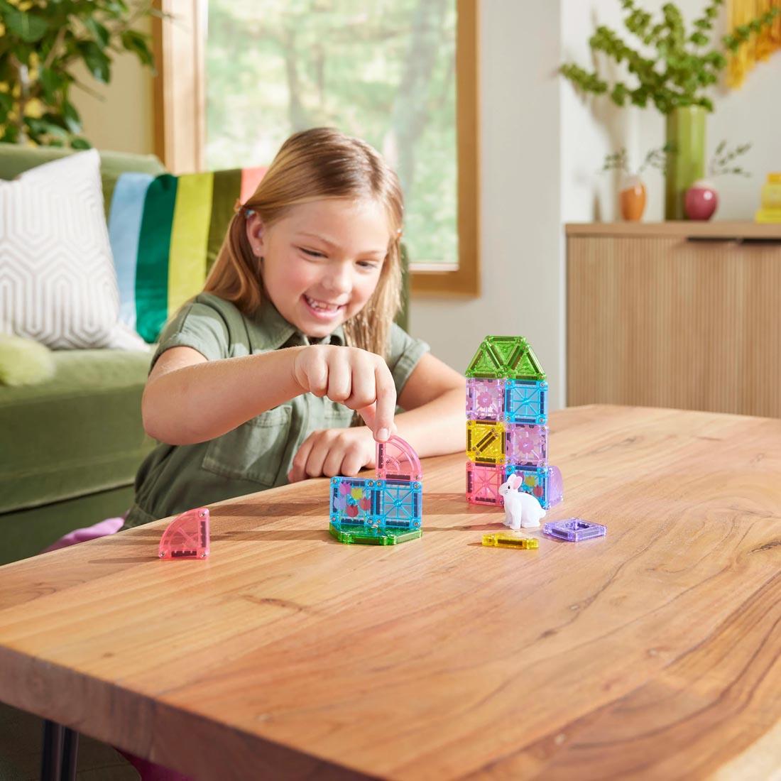 child playing with the Magna-Tiles microMAGS Spring Garden 24-Piece Travel Set