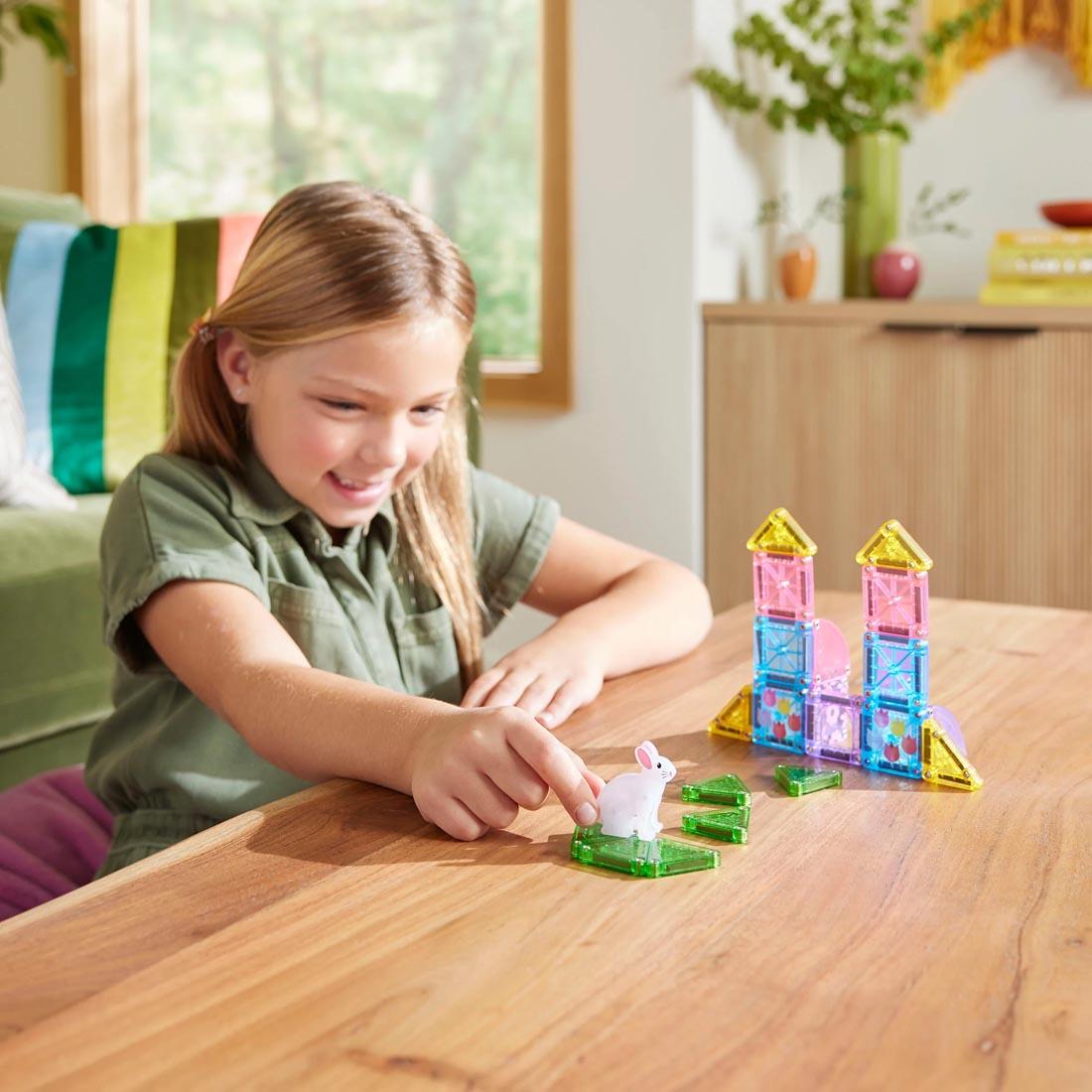 child playing with the Magna-Tiles microMAGS Spring Garden 24-Piece Travel Set