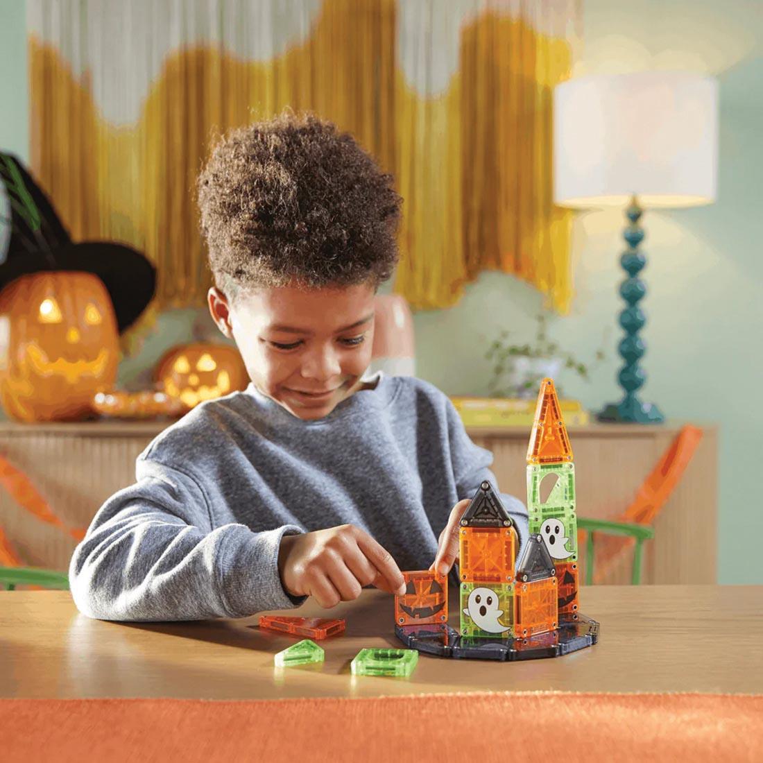 child playing with the Magna-Tiles microMAGS Spooky 24-Piece Travel Set