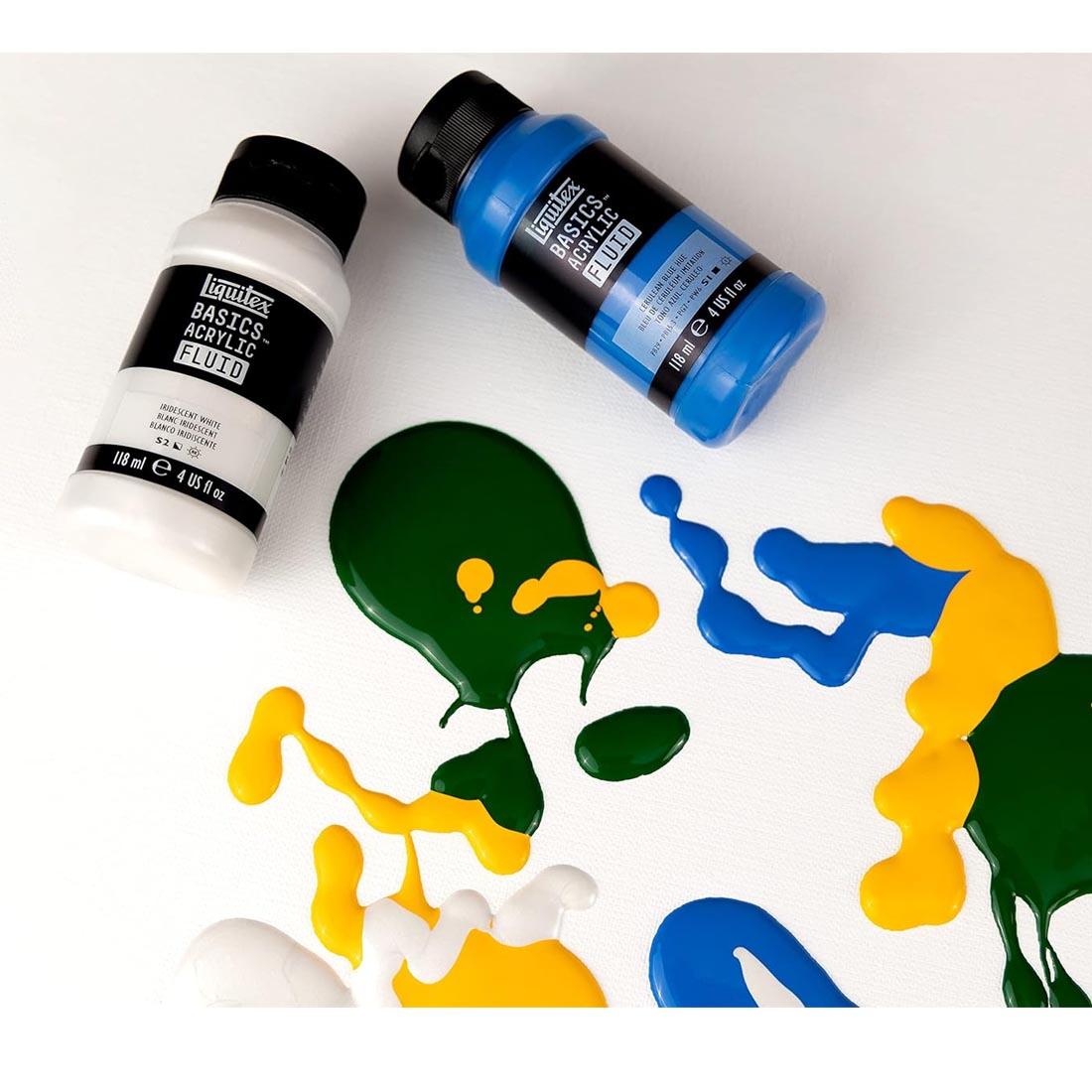 two bottles amongst paint dribbles from the Liquitex Basics Acrylic Fluid 6-Color Set