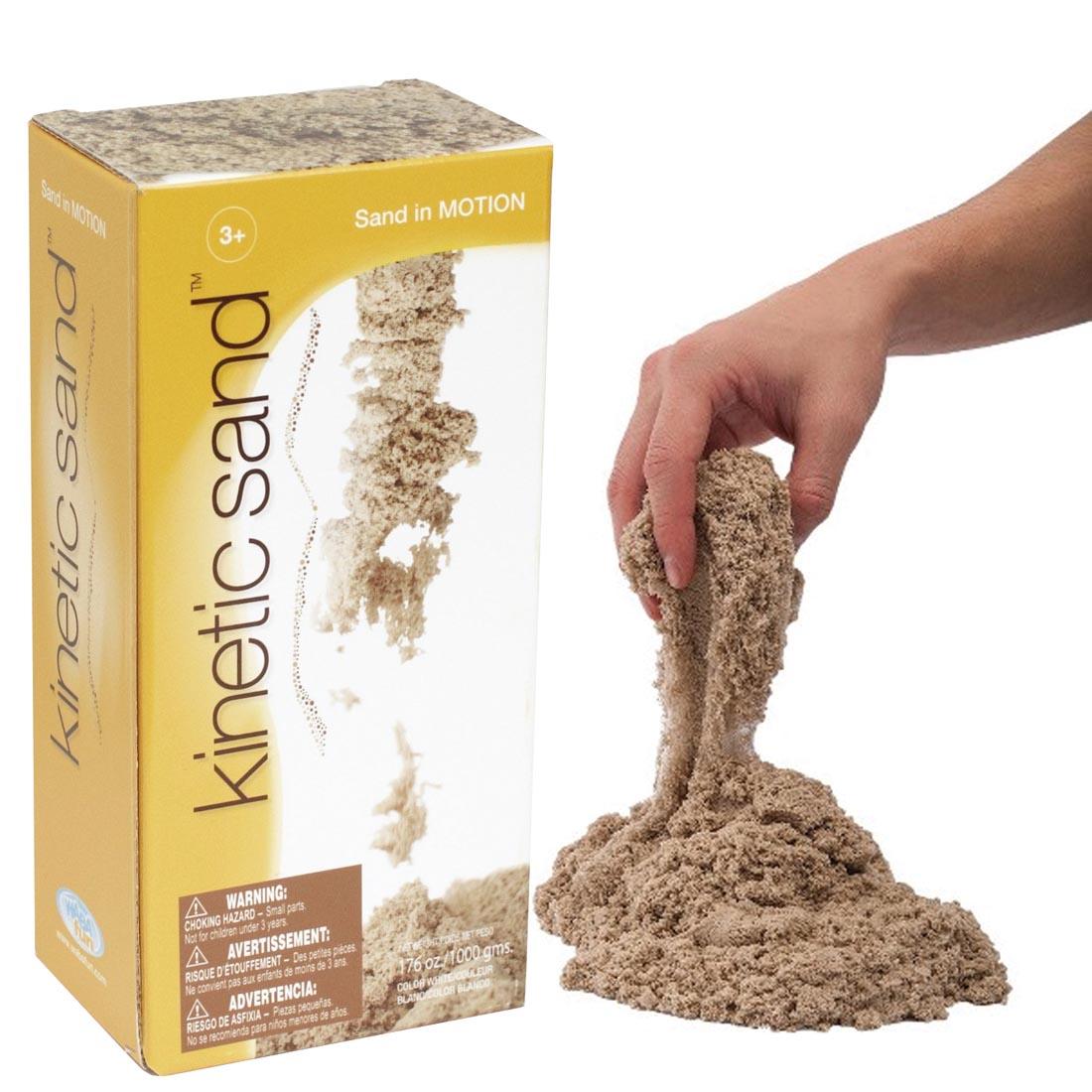 2.2 lb. package of Kinetic Sand, and hand playing with sand on the side