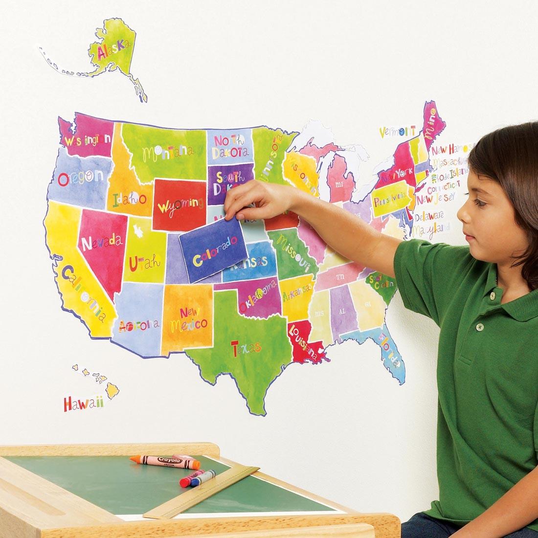 Wallies US State Map Vinyl Decals, shown on a wall, with a child putting on the last state