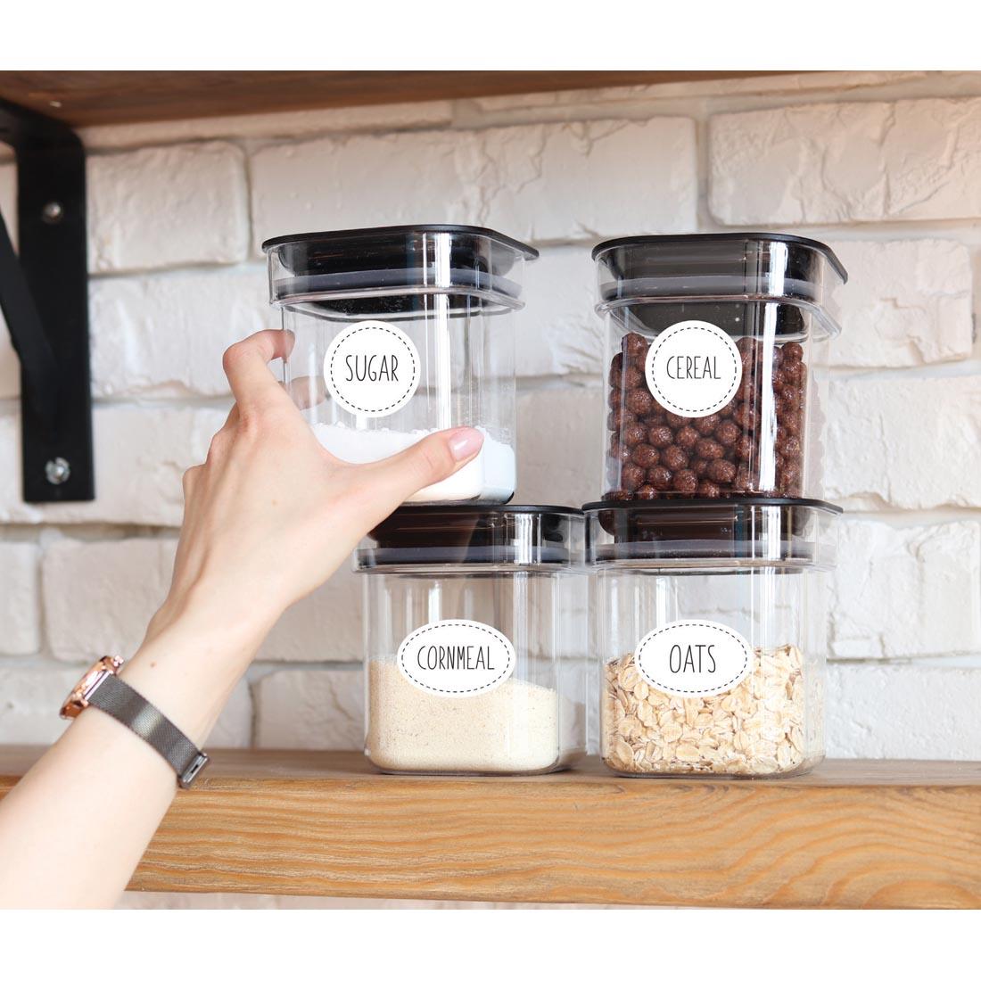 hand reaching for a canister that is labeled with Wallies Oval & Circle Dry Erase Labels