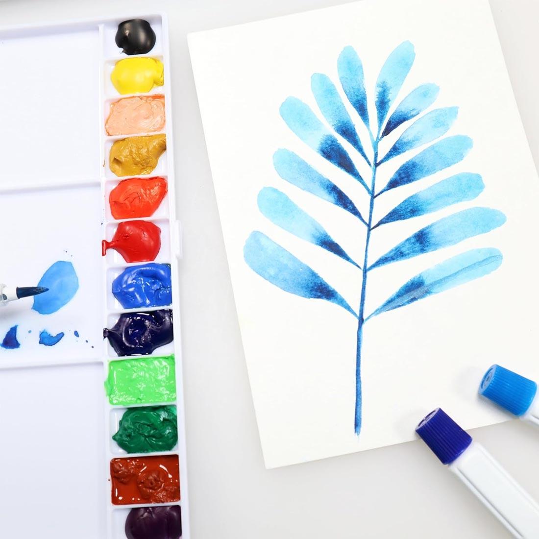 painting and two paint tubes next to a filled palette from the Niji Watercolor Aquarelle 15-Color Set